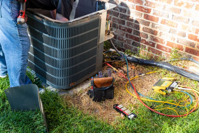 HVAC technician inspecting the interior of an AC unit