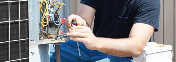  HVAC technician working on repairing an air conditioner 