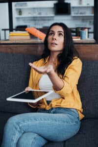 A woman looks surprised as water drips from her ceiling 