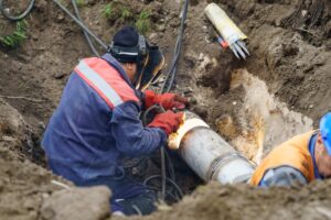 Plumbing specialists work on a water main pipe 