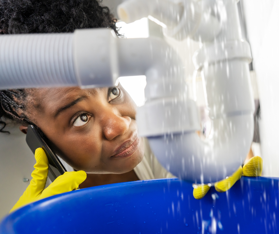 A woman calling a plumber to fix her busted pipe