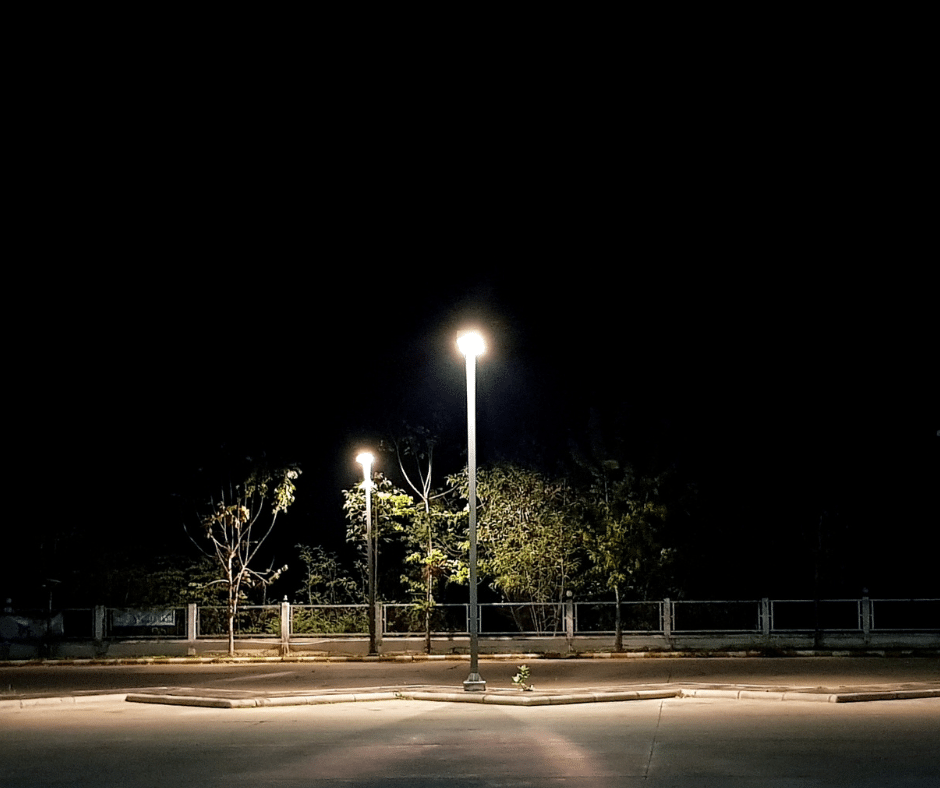 A street light illuminates a parking lot, enhancing visibility and safety during nighttime hours.
