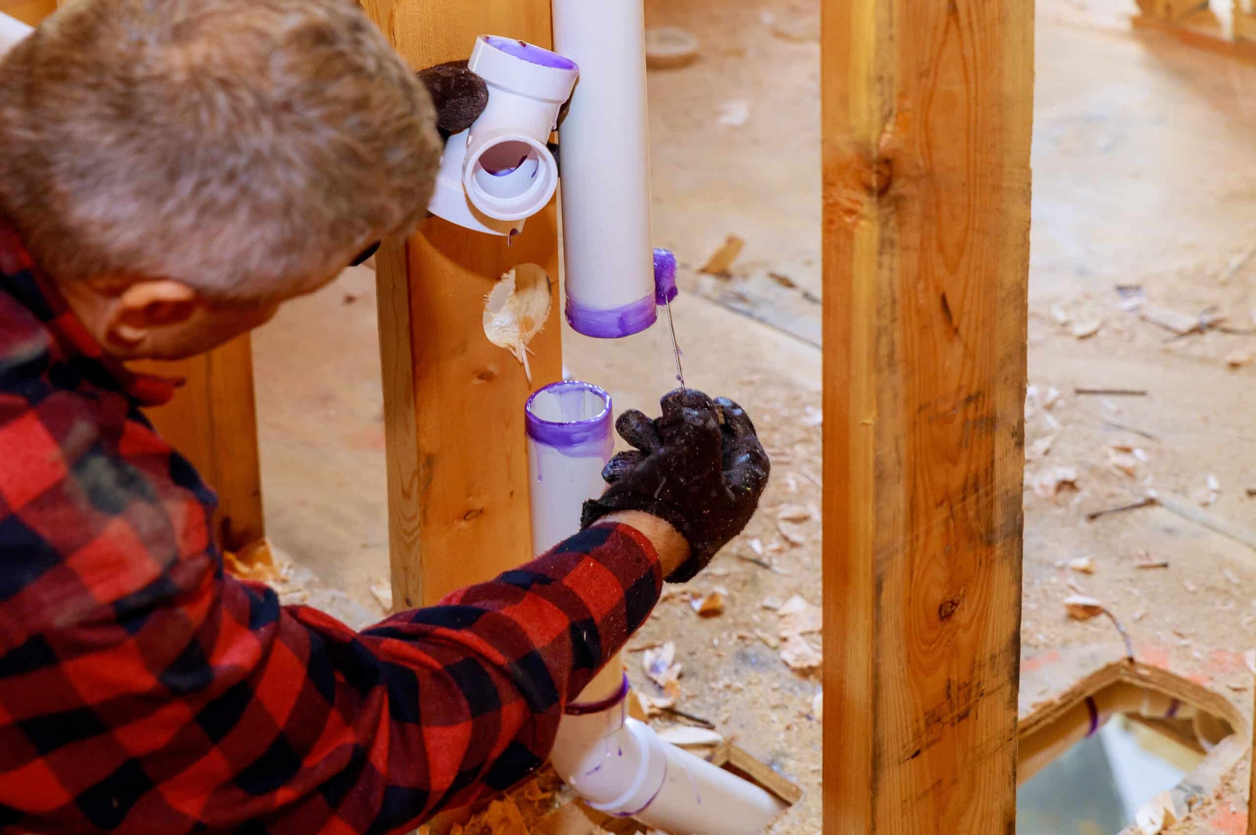A plumber assembling PVC drain pipes 