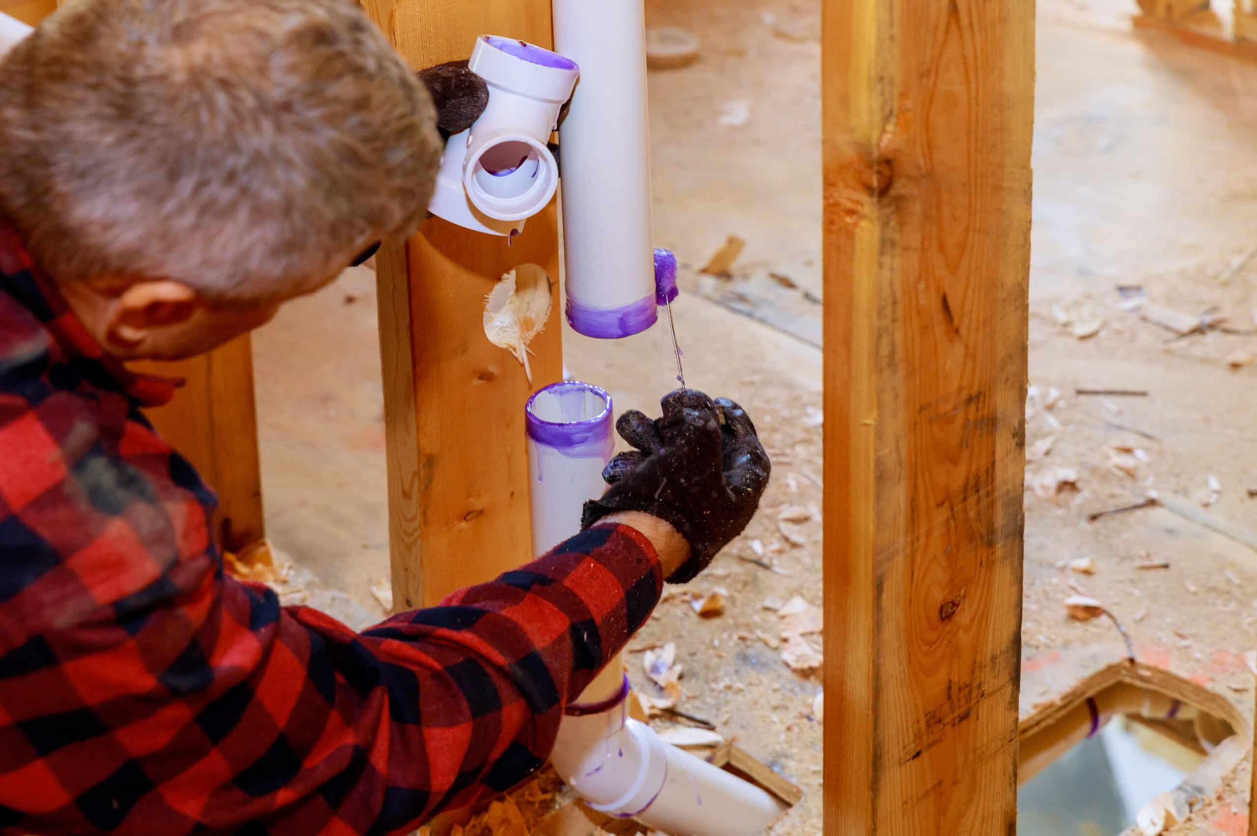 A plumber assembling to replace PVC drain pipes 