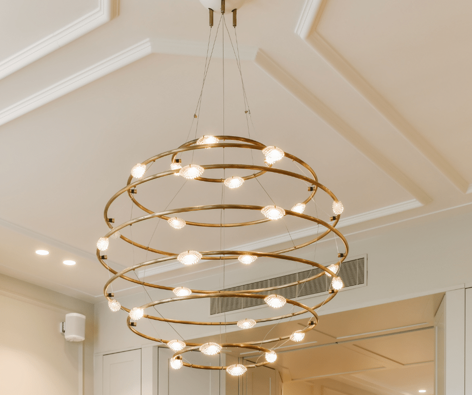 A  chandelier light fixture hangs from the ceiling  
