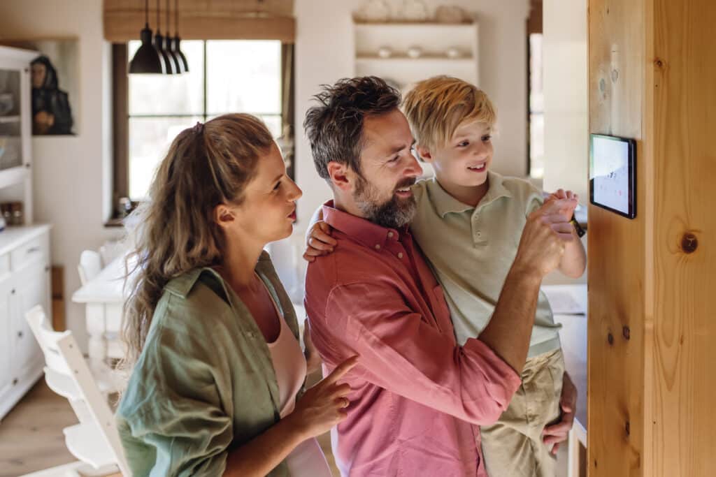 Family looking at smart thermostat for new HVAC system upgrade